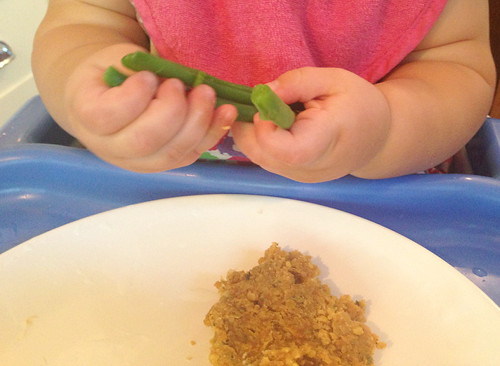 Baby eating steamed green beans